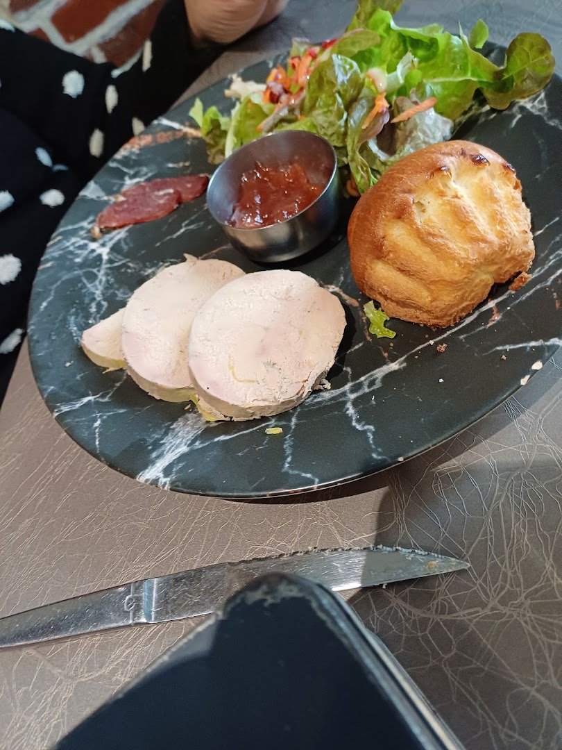 Table de restaurant avec plats régionaux et verres de bière.