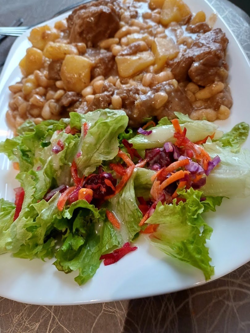Table de restaurant avec plats régionaux et verres de bière.