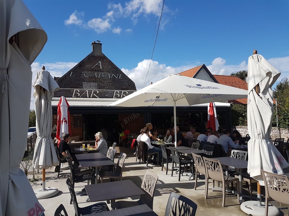 Terrasse couverte d’un restaurant, vue sur un cadre verdoyant.